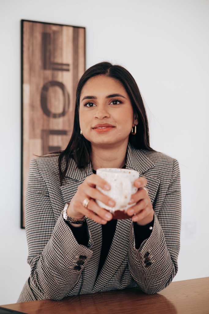 Alida with a coffee mug looking outside