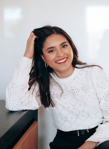 Alida laughing in a calm settting with a white shirt. Emotional Health and mental well-being